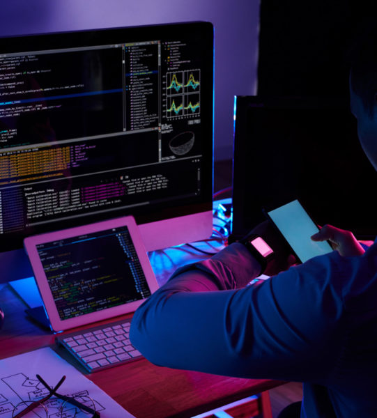 Programmer scanning screen on his smartwatch with smartphone camera